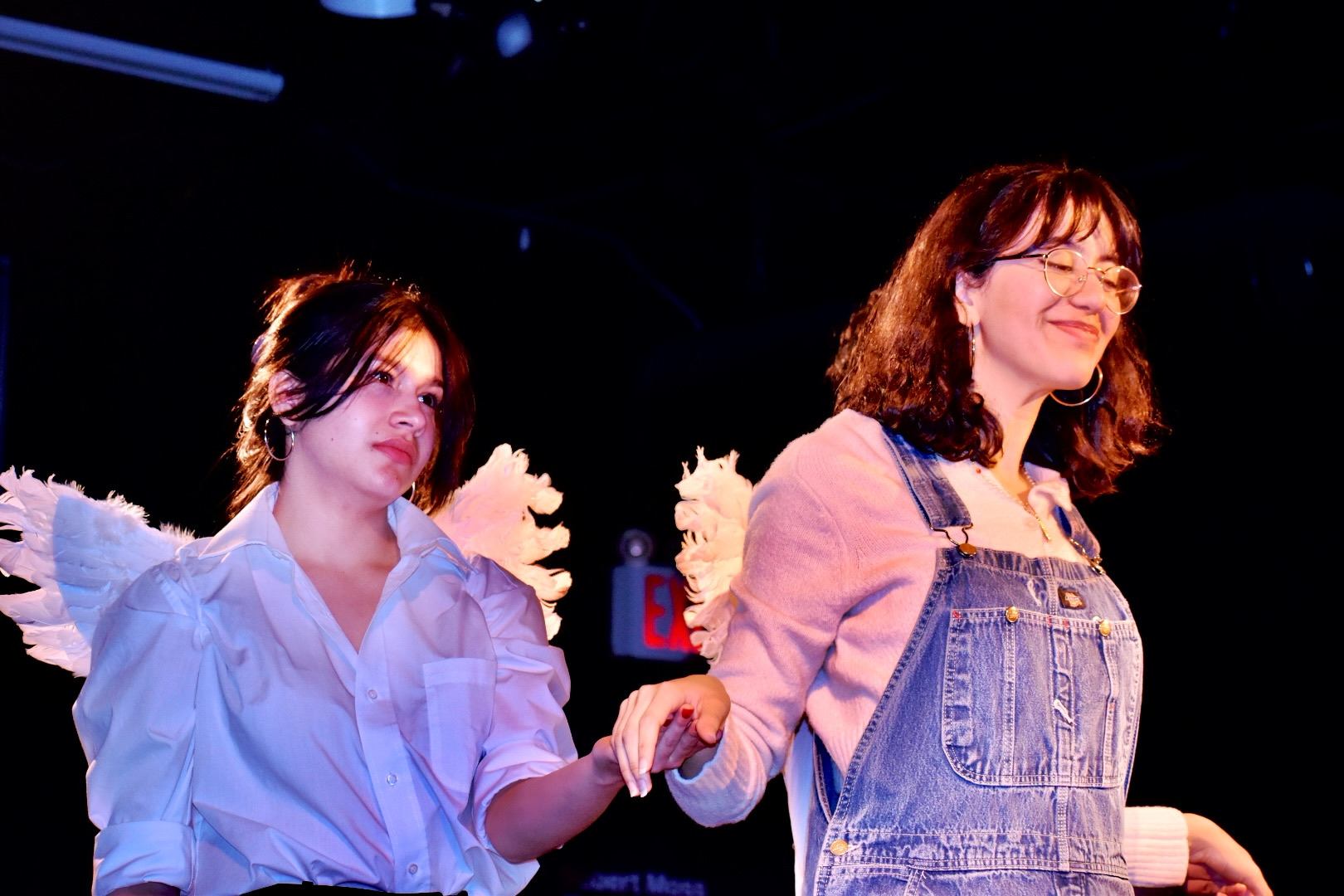 Anneth Paola Davis in a winged costume during a stage performance under theatrical lighting